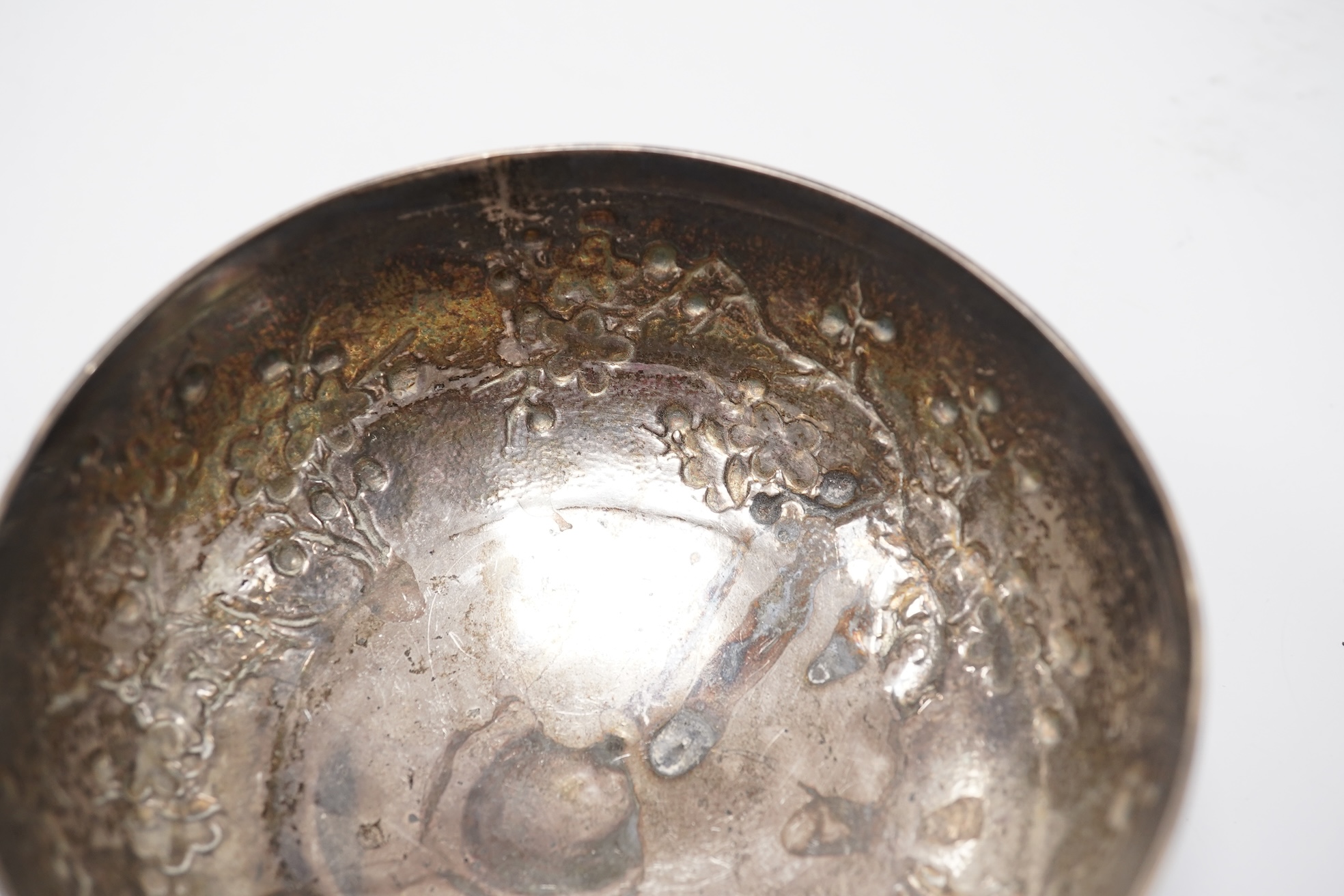 A late 19th/early 20th century Chinese Export white metal bowl, by Wang Hing, Hong Kong, embossed with blossoming prunus branches, diameter 10.6cm, 113 grams.